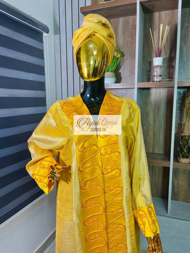 The Aurelia gold dress with orange embroidery and matching headwrap by Ayish Qasim