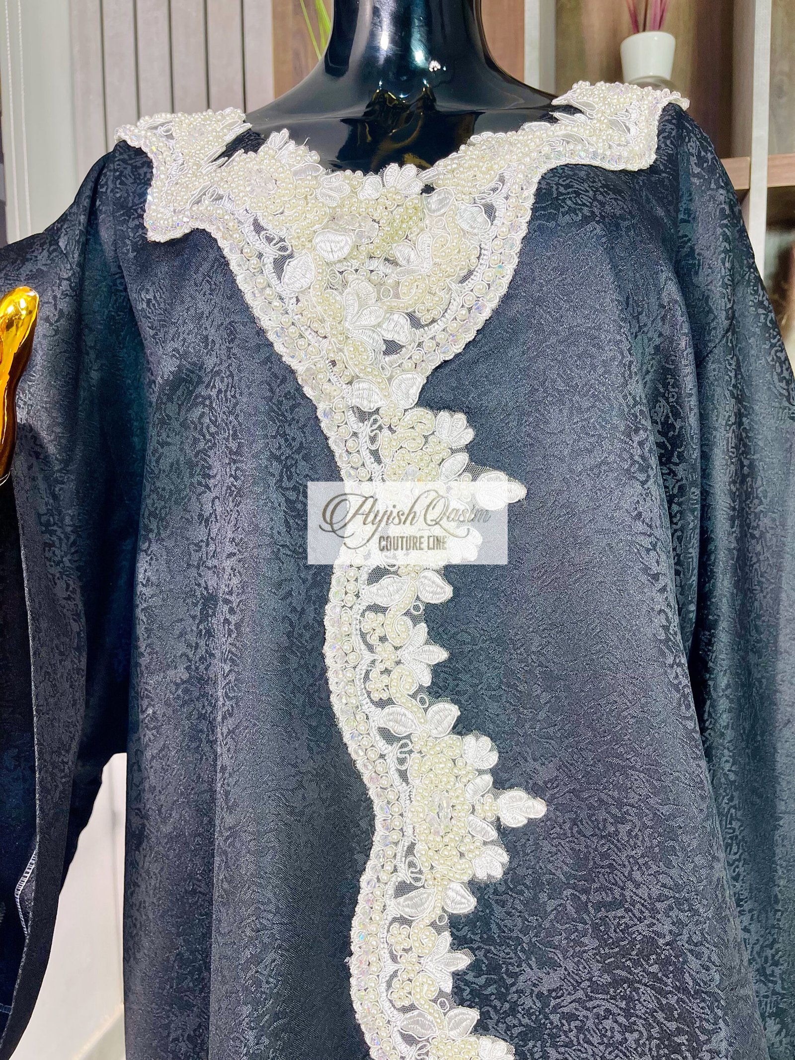 The Noir Étoile black African dress with ivory lace detailing and wide sleeves by Ayish Qasim