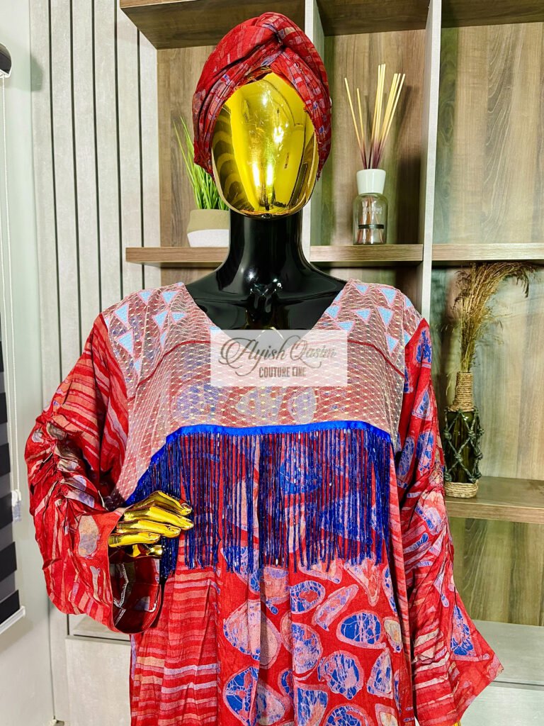 The Ruby Tapestry red African dress with blue patterned detailing and statement sleeves by Ayish Qasim